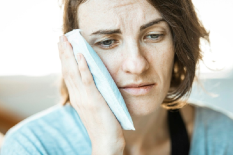 Woman holding his mouth due to tooth pain.