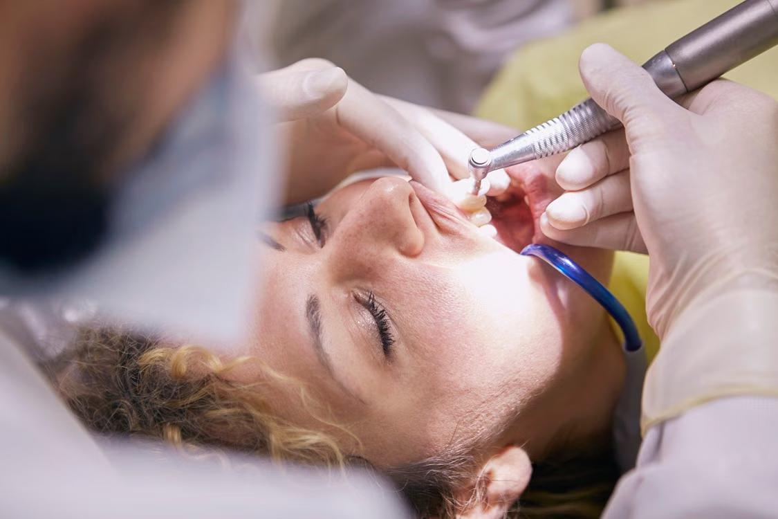 a woman getting her teeth cleaned.