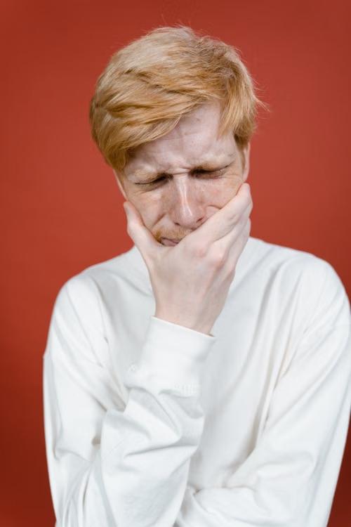 a man in a white shirt experiencing dental pain.